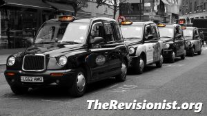 black taxi cabs lined up on the curb
